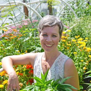 cannabis coach in the cannabis garden holding cannabis plants